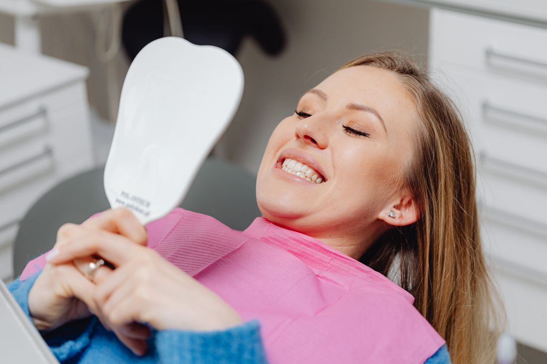 Smiling patient looking in a mirror after dental care